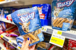 hand holding a bag of purina busy bone dog treats