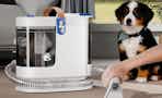 a carpet cleaner sitting on a floor with a dog