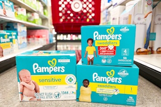 3 pampers diapers and wipes boxes sitting on the floor in front of a target cart