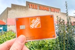 someone holding a Home Depot credit card in front of Home Depot