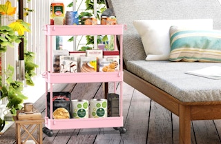 a pink cart with items on a patio