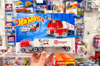 hand holding a hot wheels bulleye's big rig set in front of target shelves