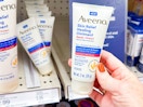 hand holding aveeno healing ointment in front of a target shelf