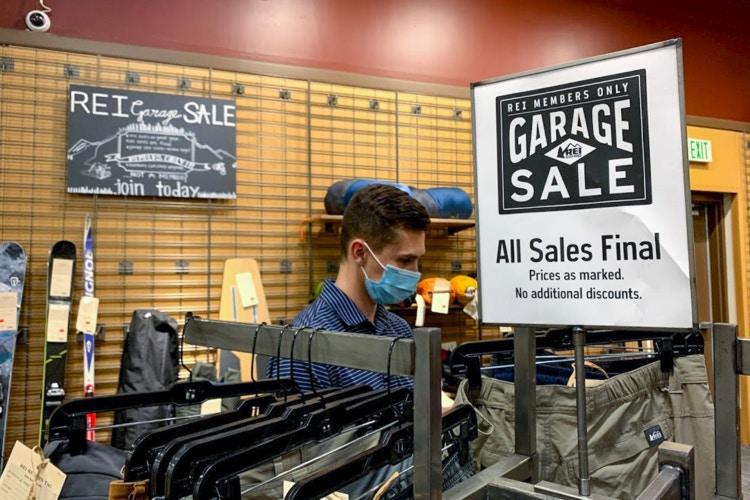 Man looking through the clothes in the Garage Sale section at REI