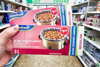 person holding 2 boxes of slow cooker liners in a dollar tree aisle