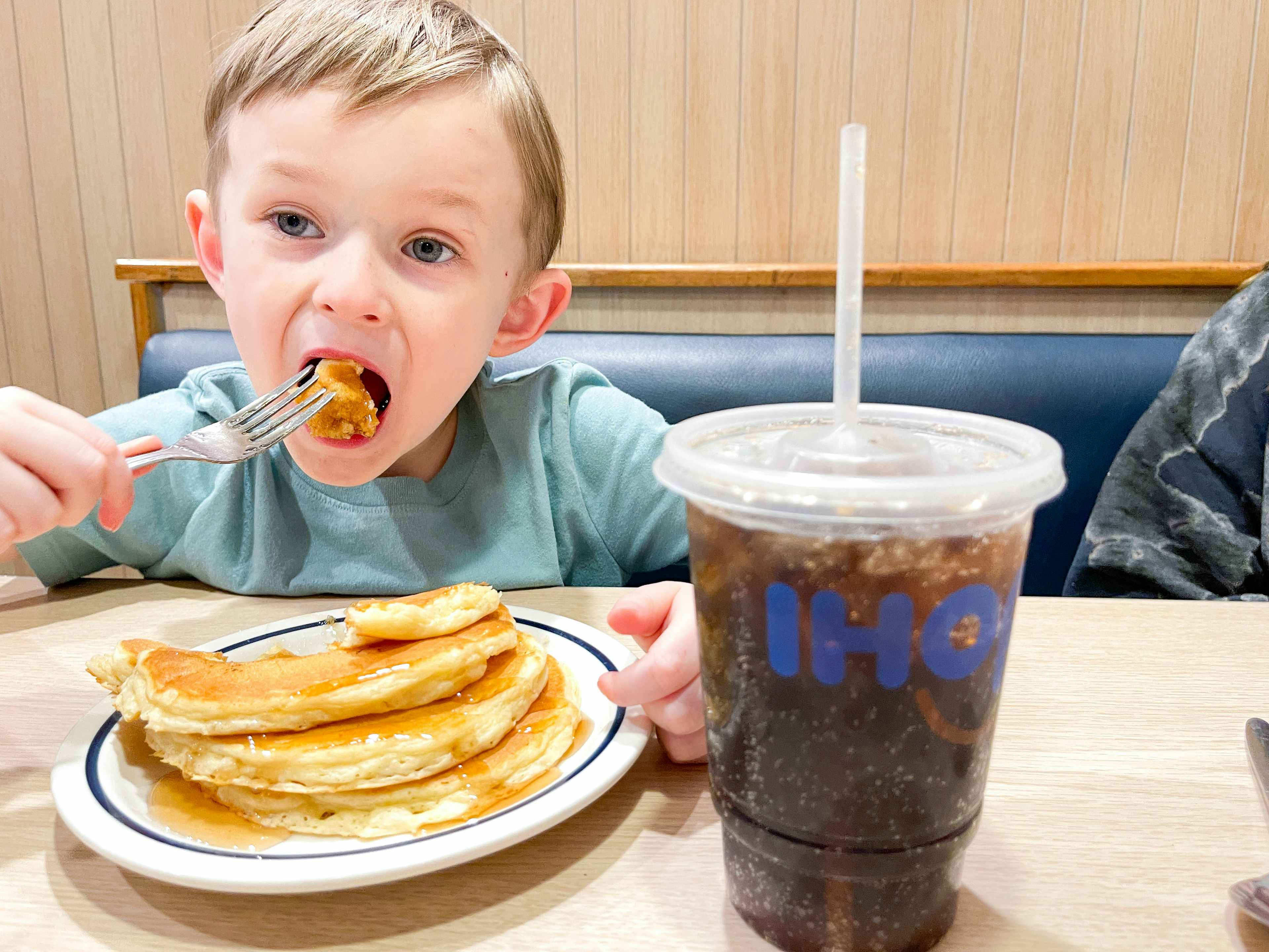 a little boy eating pancakes