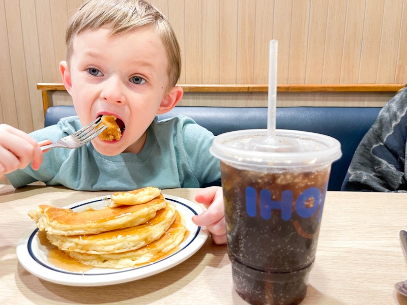 a little boy eating pancakes