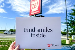walgreens photo envelope being held outside a walgreens store