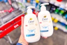 hand holding two bottles of dove hand soap next to a cvs shopping cart
