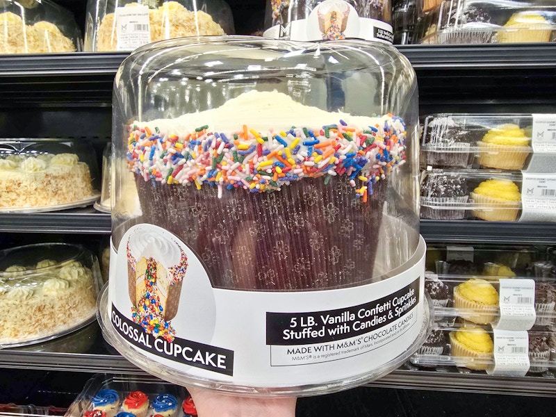 person holding a 5-pound colossal cupcake filled with candy