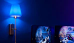 a wall scone with a blue light next to a TV