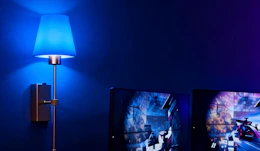 a wall scone with a blue light next to a TV