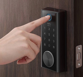 A person touching a Eufy deadbolt.