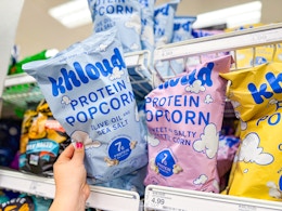 hand holding a bag of khloud popcorn on target shelf