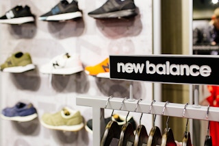 A clothing rack by a shoe display in a New Balance store