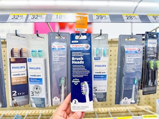 person grabbing a package of toothbrush heads