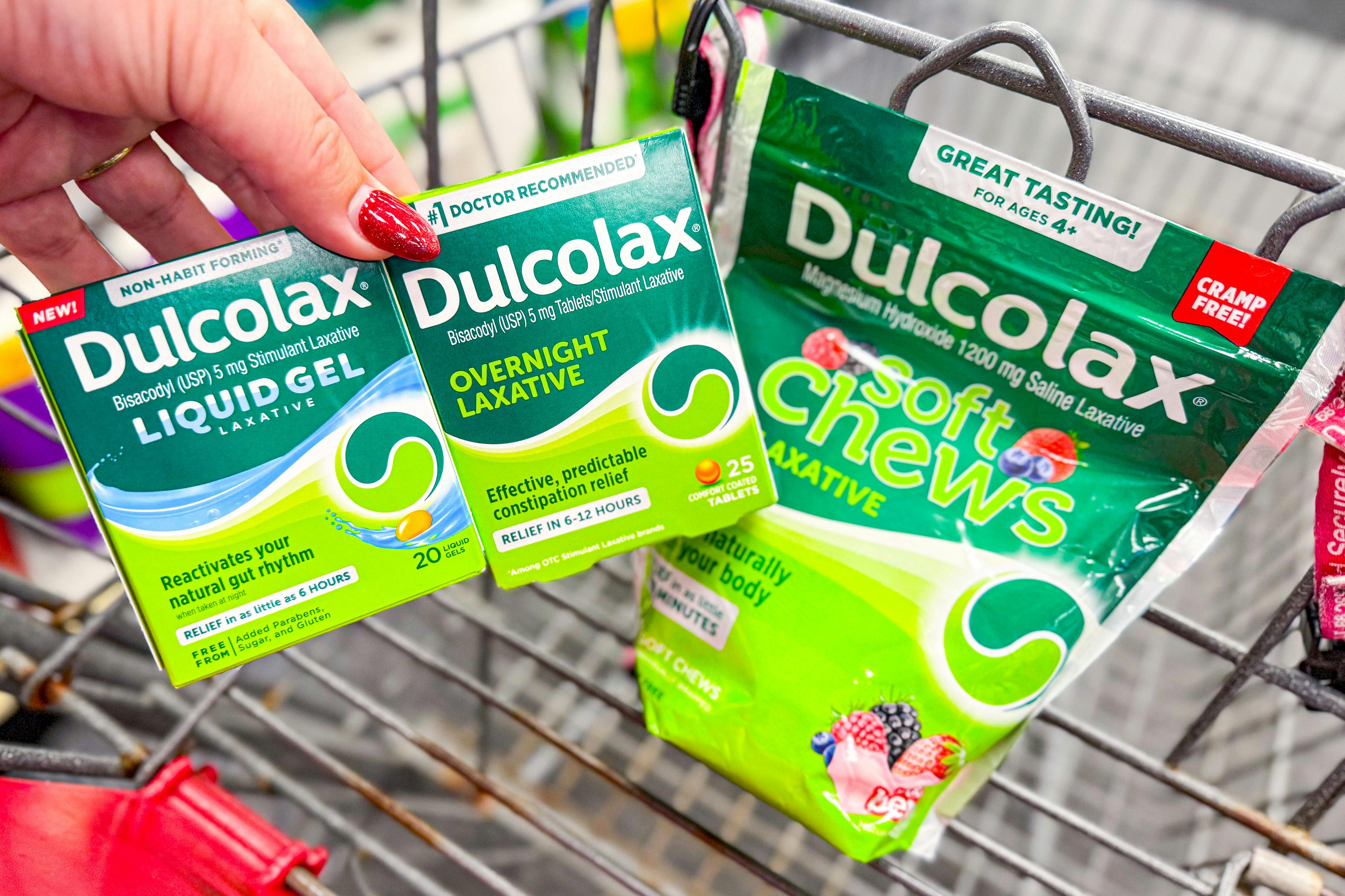 hand holding dulcolax products over a shopping cart