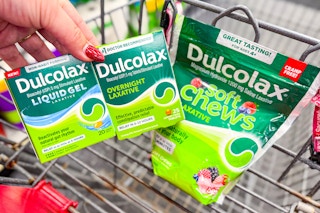 hand holding dulcolax products over a shopping cart