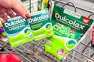 hand holding dulcolax products over a shopping cart