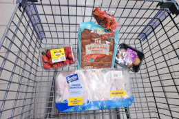 strawberries, hawaiian rolls, mushrooms, and chicken drumsticks in a cart