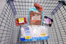 strawberries, hawaiian rolls, mushrooms, and chicken drumsticks in a cart