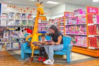 mother and child looking at toy catalog in macy's toys r us