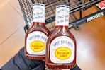 hand holding bottles of sweet baby rays bbq sauce