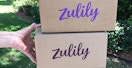 a person holding two zulily boxes stacked on top of each other