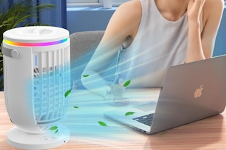 a woman sitting next to a portable A/C