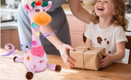 a pink stuffed giraffe toy on a table 