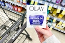 person holding an olay moisturizer over a walgreens cart