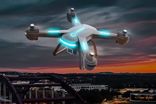 Lifestyle image of a drone being flown of over the night sky (city landscape)
