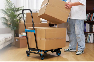 man taking boxes off dolly cart