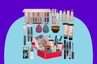 A variety of makeup items in a set, including eyeshadow, lipstick, foundation applicators, brush, mascara, foundation, eyeliner and more.