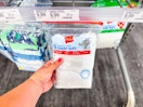 hand grabbing a 5-pack of hanes toddler tees off a target shelf
