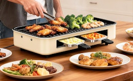 a person cooking on an electric grill at a table 