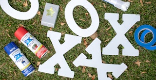 x and o letters with spray paint and clothesline on grass