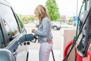 A person filling their vehicle with gas at a gas station pump.