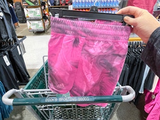 pink adidas shorts being put in shopping cart