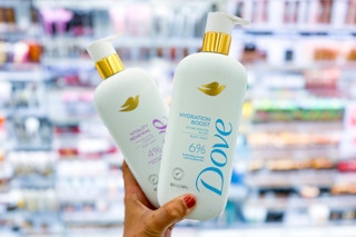 hand holding two bottles of dove body wash
