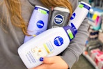 person holding bottles of nivea body wash in front of their body