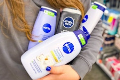 person holding bottles of nivea body wash in front of their body