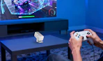 a mini projector on a table in a room in front of a TV