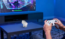 a mini projector on a table in a room in front of a TV