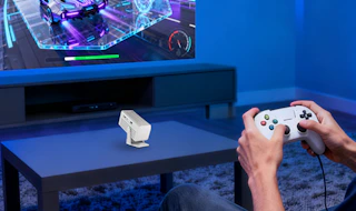 a mini projector on a table in a room in front of a TV
