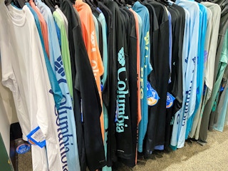 A variety of Columbia shirts hanging on a rack in Kohls