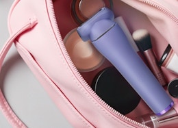 a purple electric razor in a pink makeup bag