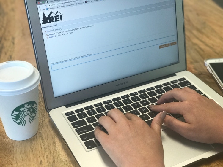 Laptop showing customer service chat on REI website