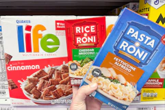 hand holding pasta-roni next to life cereal