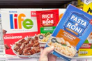 hand holding pasta-roni next to life cereal